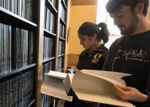 Writing your thesis Two students looking to the thesis archive in Chapman Hall