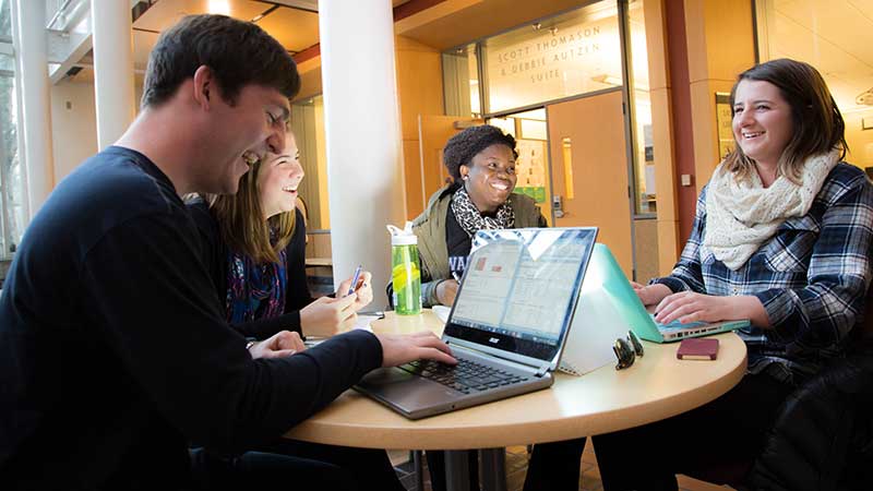 Students sitting around a table laughing