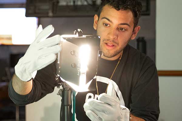 Student setting up lighting for a video shoot